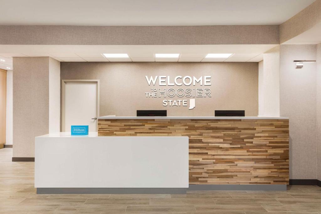 a welcome desk in a lobby with a welcome theoser sign at Hampton Inn & Suites Valparaiso in Valparaiso