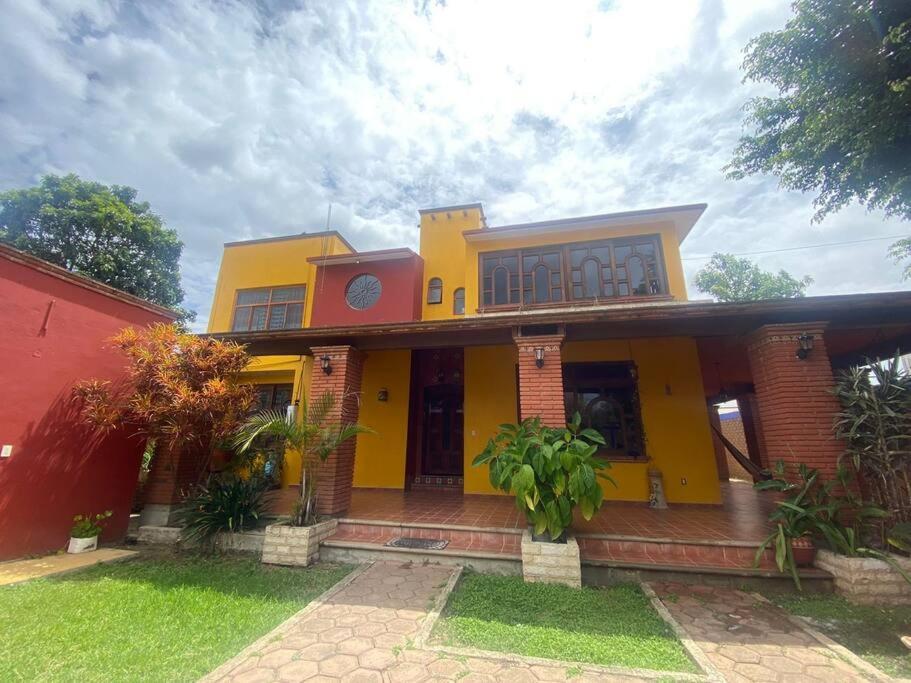 a yellow and red house with a red at Casa Lídxi Beexha in Santa María Azompa