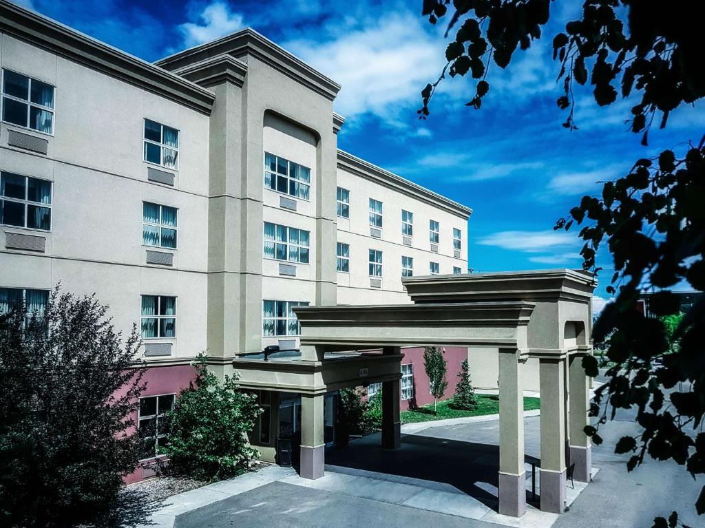 um grande edifício branco com um arco em frente em Hampton Inn & Suites by Hilton Edmonton International Airport em Leduc