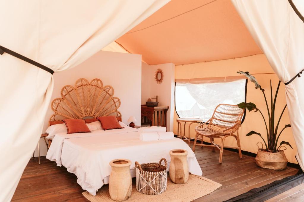 Un dormitorio con una cama grande y una silla. en Dreamsea Mediterranean Camp, en Benitachell