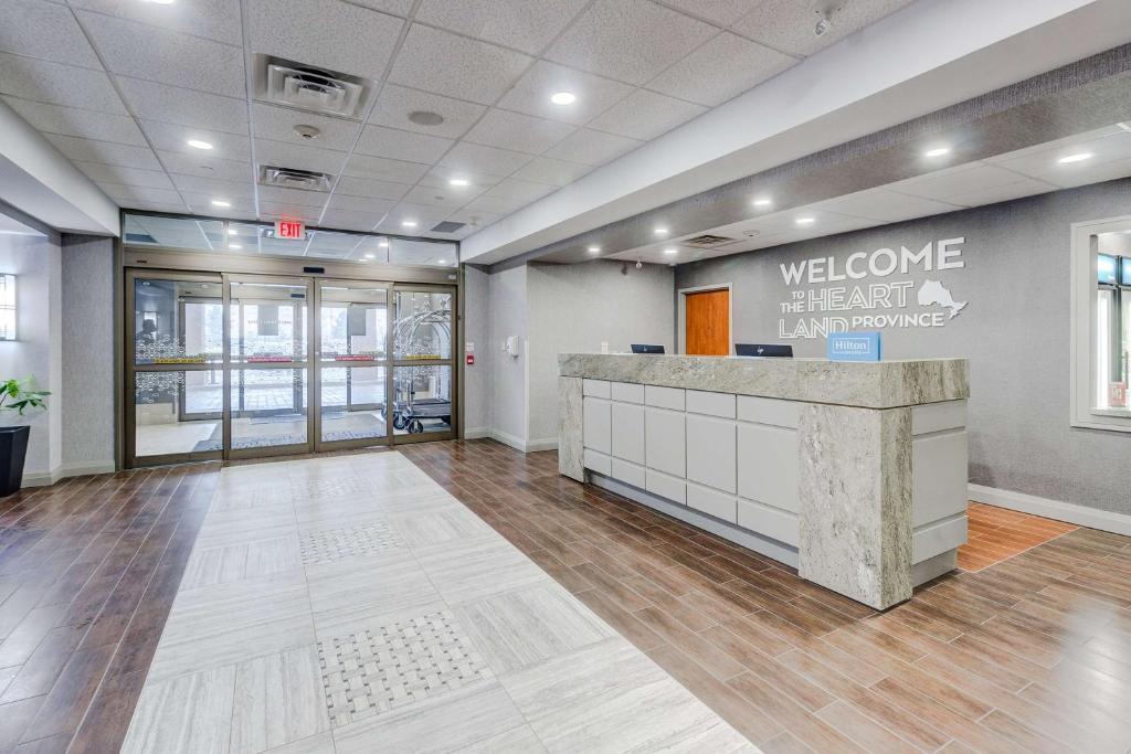an office lobby with a welcome sign on the wall at Hampton Inn & Suites by Hilton Brantford in Brantford