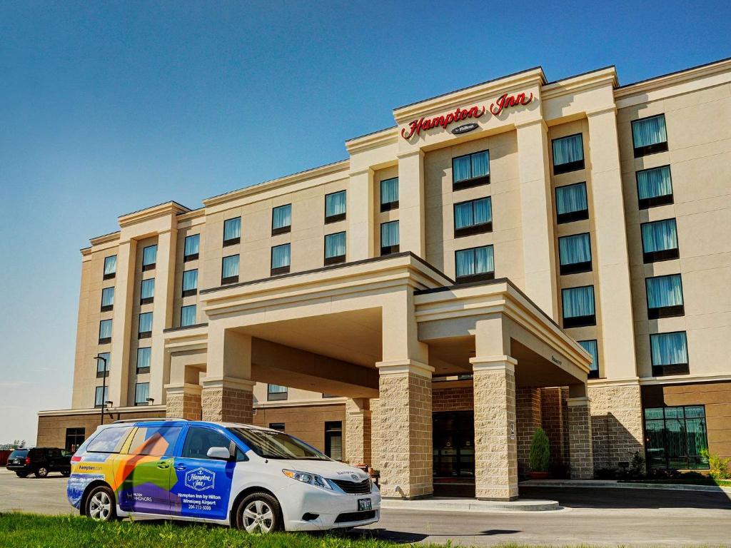 Hampton Inn by Hilton Winnipeg في وينيبيغ: فندق تقف امامه سيارة