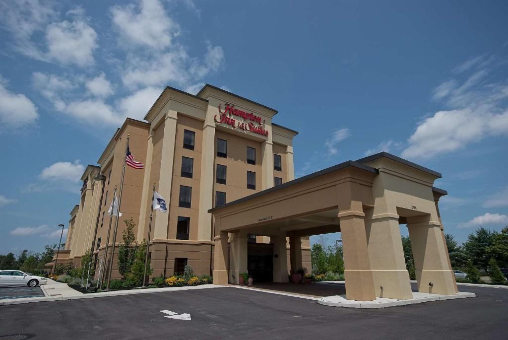 a hotel building with an american flag on top of it at Hampton Inn & Suites Vineland in Vineland