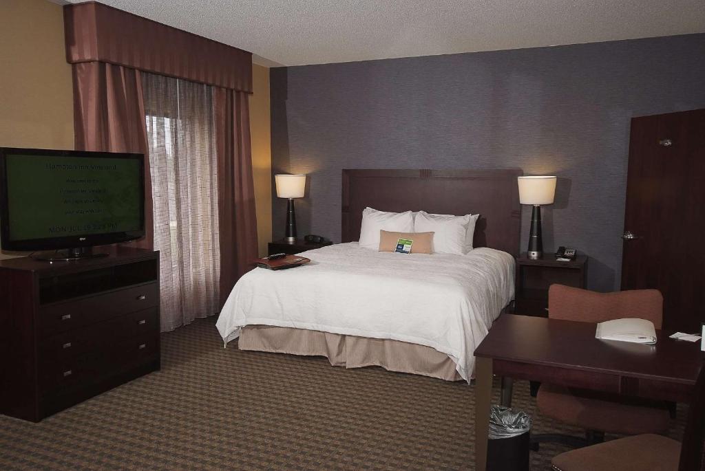 a hotel room with a bed and a desk and a television at Hampton Inn & Suites Vineland in Vineland