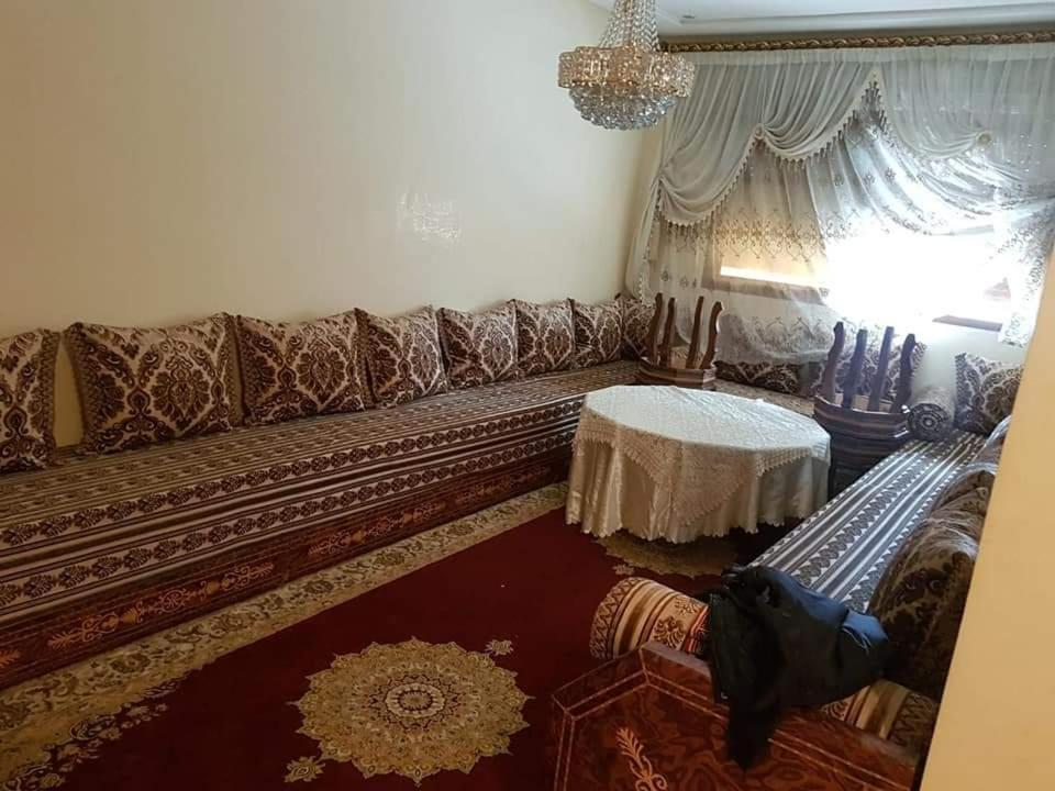 uma sala de estar com um sofá e uma mesa em إقامة الحمد em Meknès