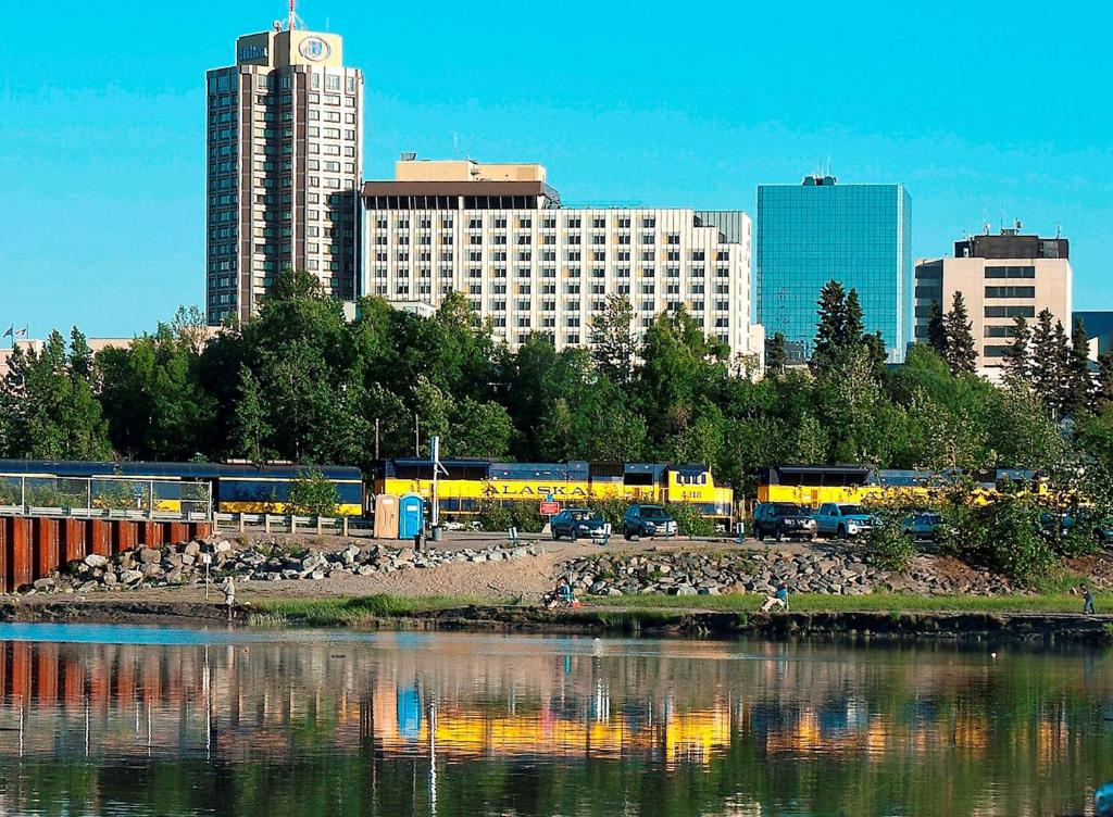 eine Stadt mit Gebäuden im Hintergrund und einem Wasserkörper in der Unterkunft Hilton Anchorage in Anchorage