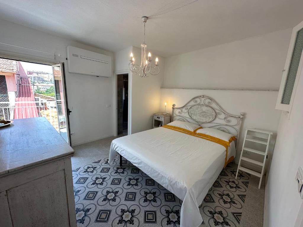 um quarto com uma cama e uma cozinha com um lustre em Favolosa stanza gialla con terrazzino vista mare Mottino23 em Lerici