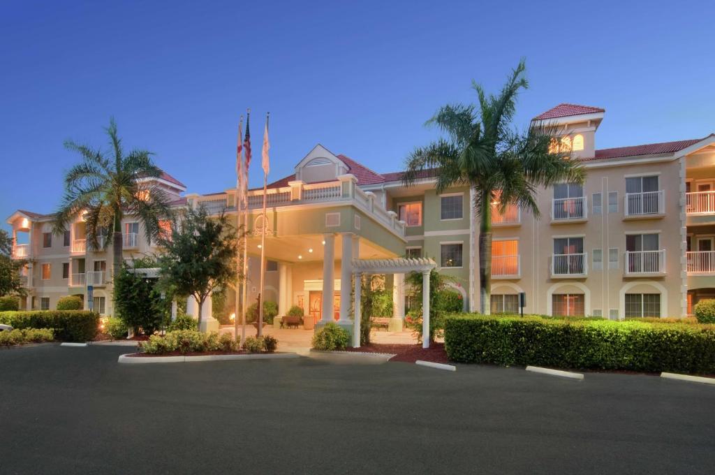 un grand bâtiment avec des palmiers devant lui dans l'établissement DoubleTree Suites by Hilton Naples, à Naples