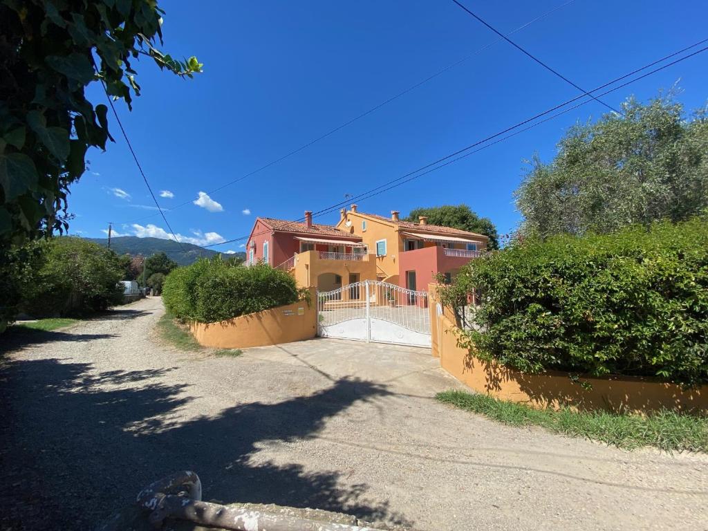 une maison avec un portail et une allée dans l'établissement Résidence LO MONACO Haut de villa, Appartements et Studios, à San-Nicolao