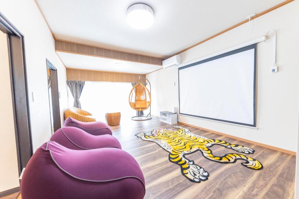 uma sala de estar com cadeiras roxas e um tapete de tigre em KANJYAKU-AN - Vacation STAY 76347v em Nakatsugawa