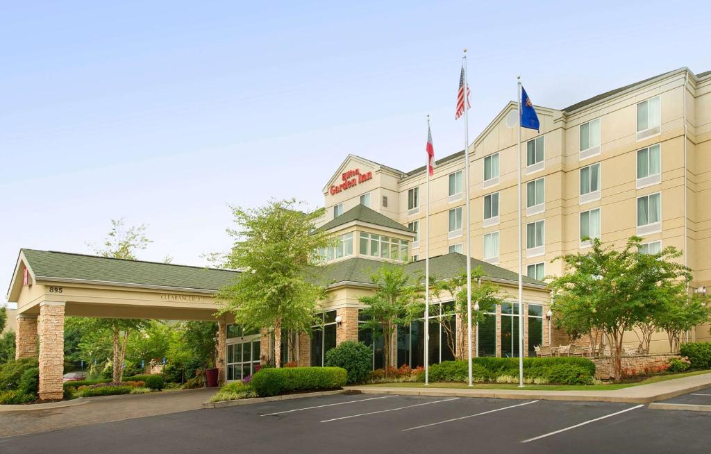 a hotel with an american flag in front of it at Hilton Garden Inn Atlanta NW/Kennesaw-Town Center in Kennesaw