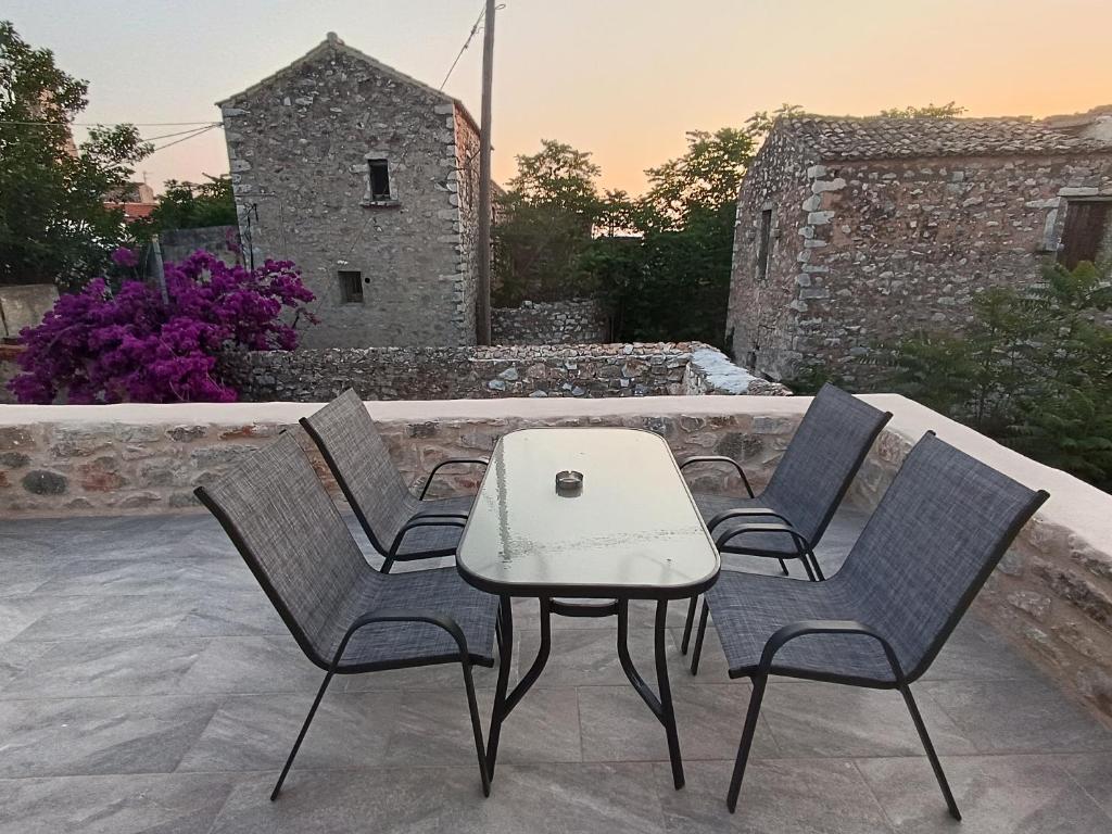 un grupo de sillas y una mesa en un patio en Mainotti's house with balcony, en Areopoli