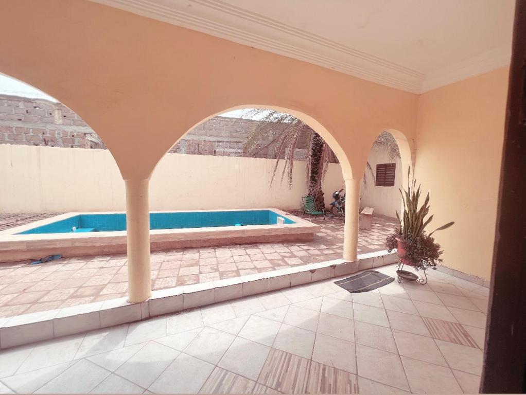 einen Pool in einem Haus mit Torbogen in der Unterkunft Villa Saran in Bamako