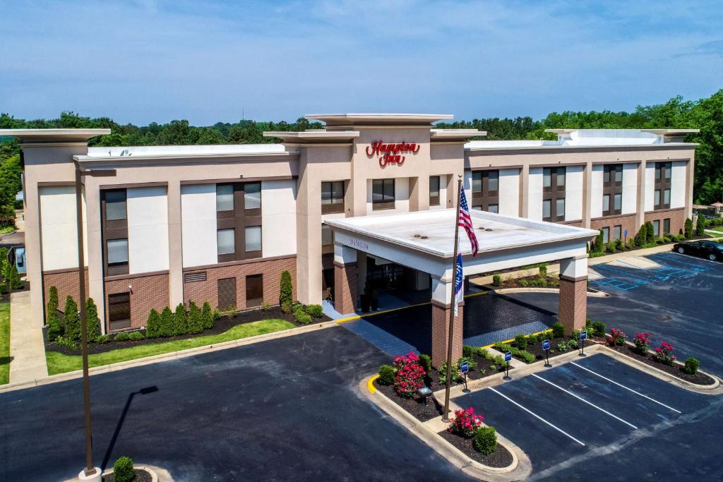 een hotel met een Amerikaanse vlag op een parkeerplaats bij Hampton Inn Batesville in Batesville