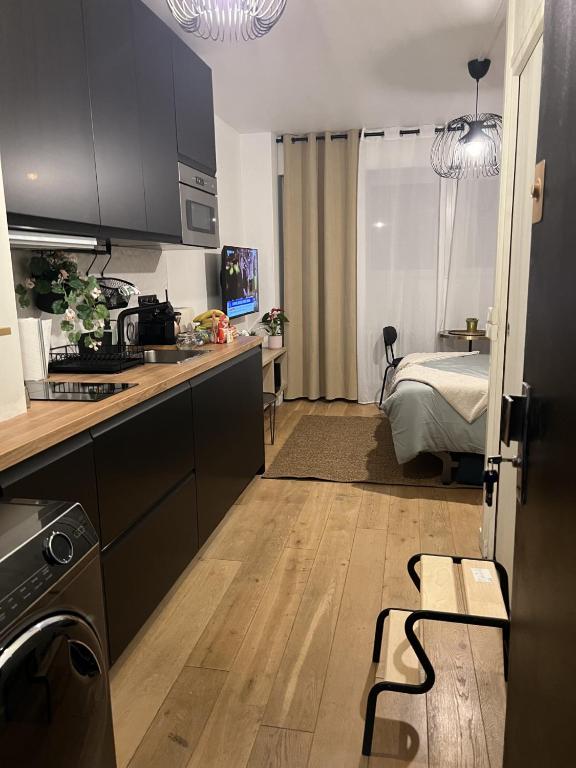 Cette chambre dispose d'une cuisine avec un lit en arrière-plan. dans l'établissement joli studio paris 16 Victor Hugo, à Paris