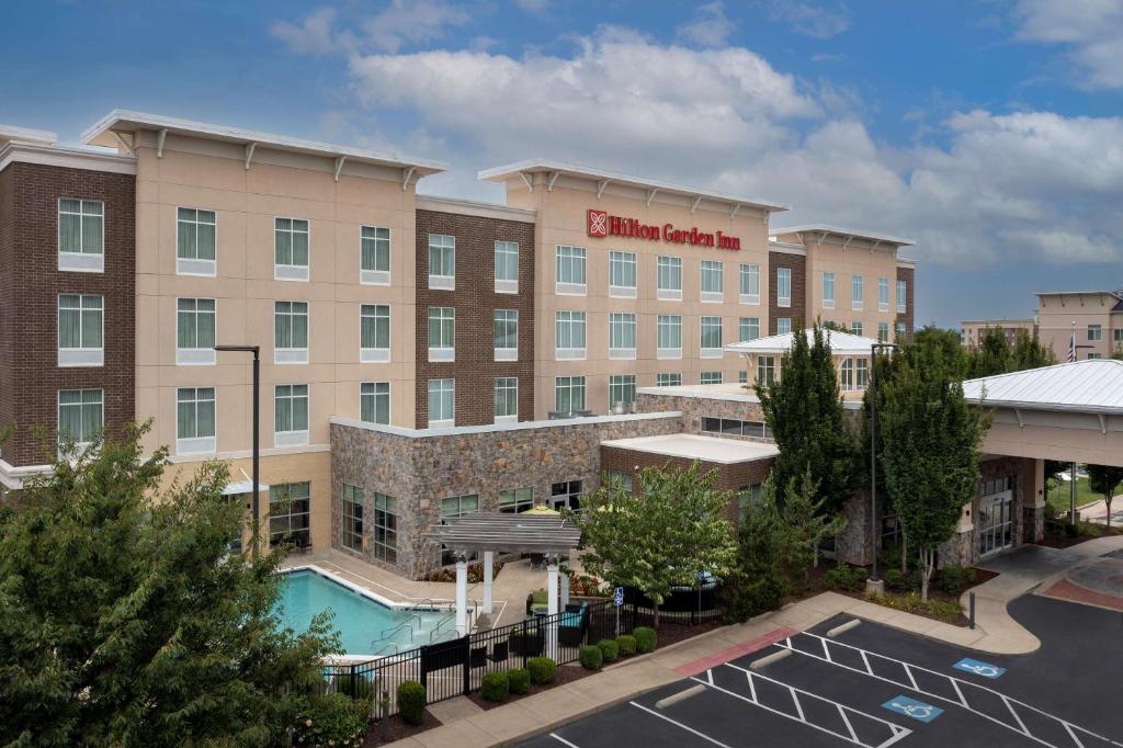 un hôtel avec une piscine dans un parking dans l'établissement Hilton Garden Inn Murfreesboro, à Murfreesboro