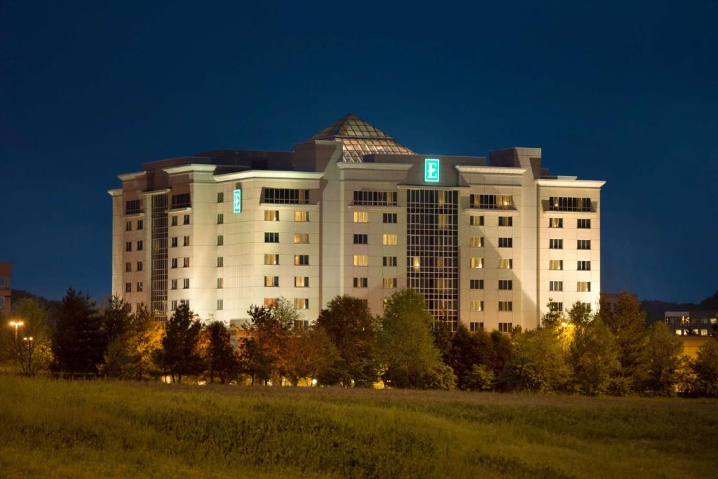 a large white building with blue lights on it at Embassy Suites by Hilton Nashville South Cool Springs in Franklin