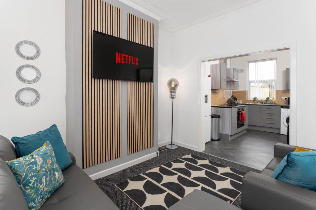 a living room with a couch and a kitchen at Woodbine House - Air Host and Stay - Free parking - Contractor Friendly in Liverpool