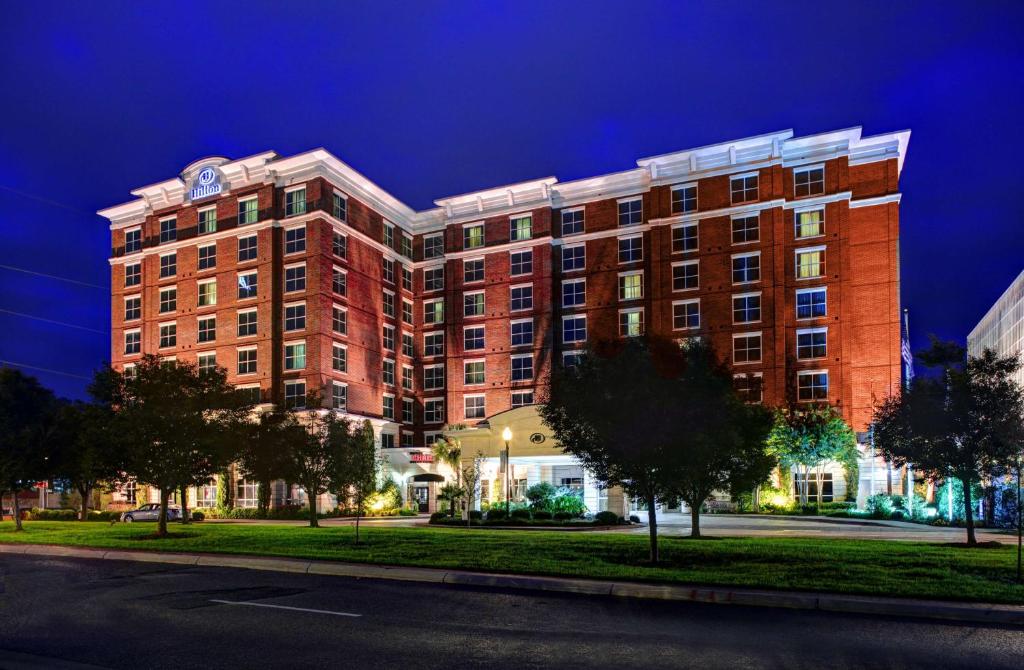 a large red brick building on a street at night at Hilton Columbia Center in Columbia