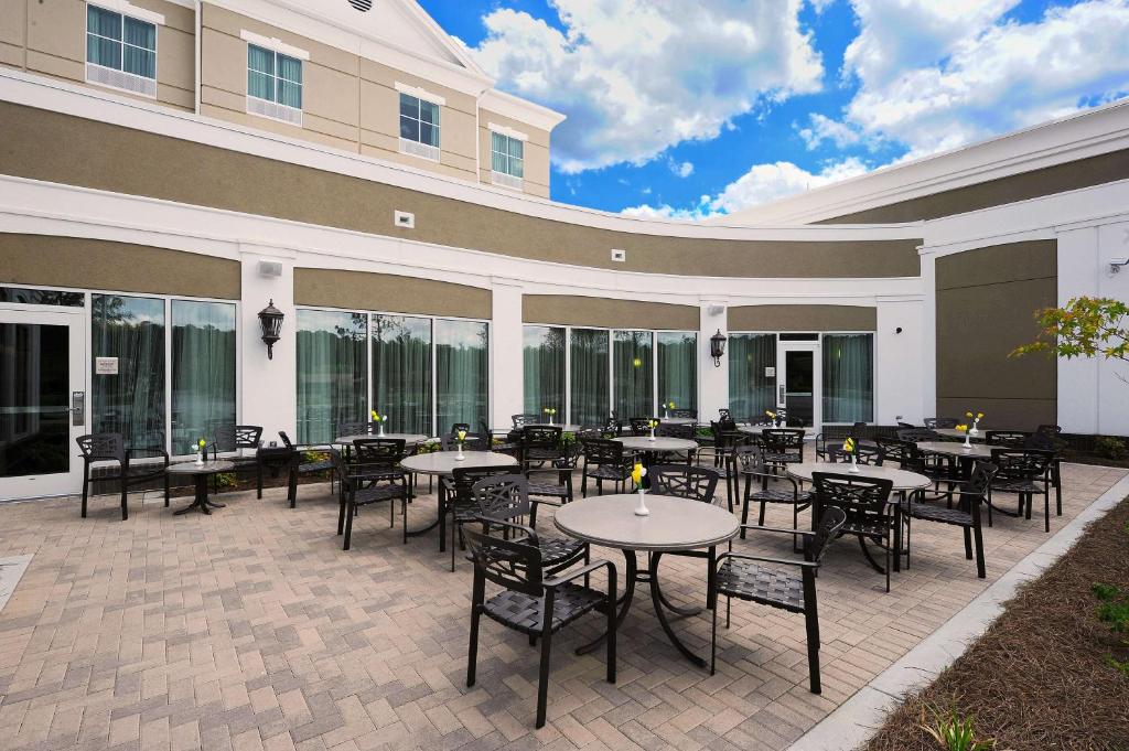 a patio with tables and chairs in front of a building at Hilton Garden Inn Columbia/Northeast in Columbia