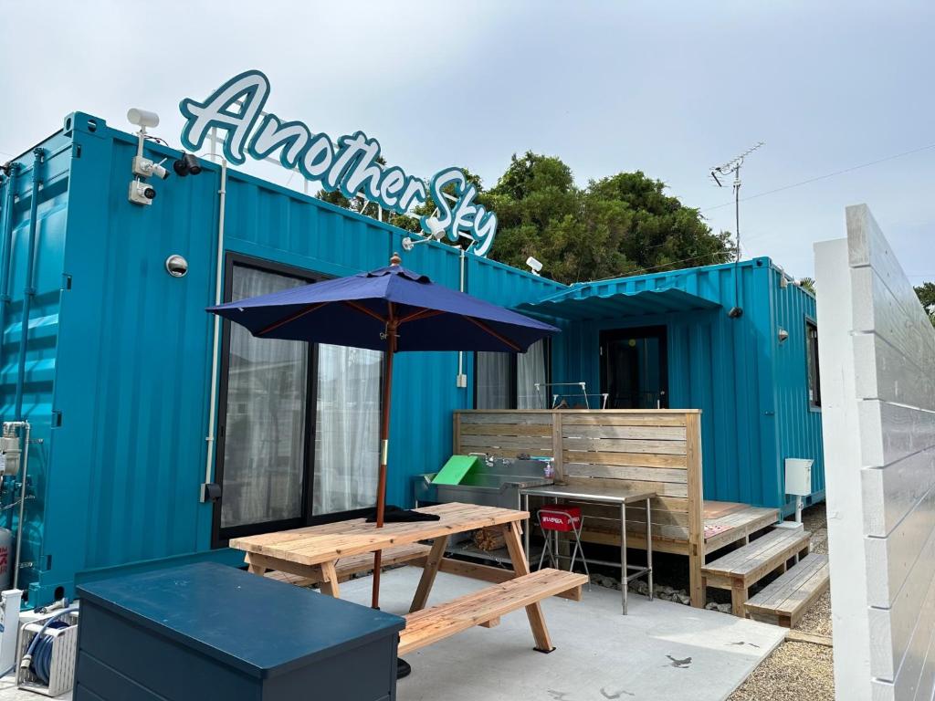 a blue building with a picnic table and an umbrella at Another sky - Vacation STAY 90163v in Miyazaki