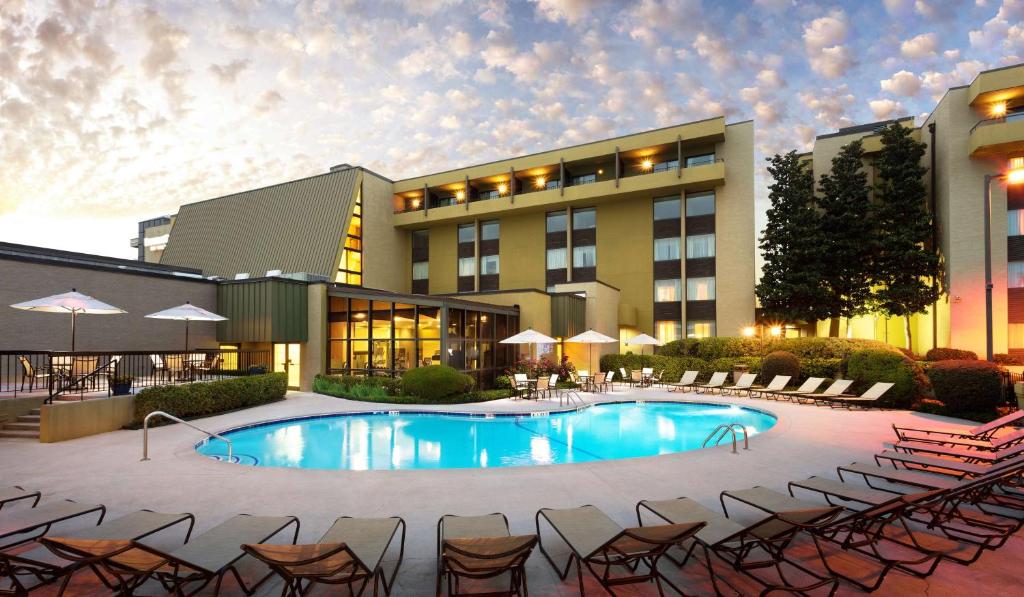 a hotel with a pool and chairs and a building at DoubleTree by Hilton Hotel Columbia in Columbia