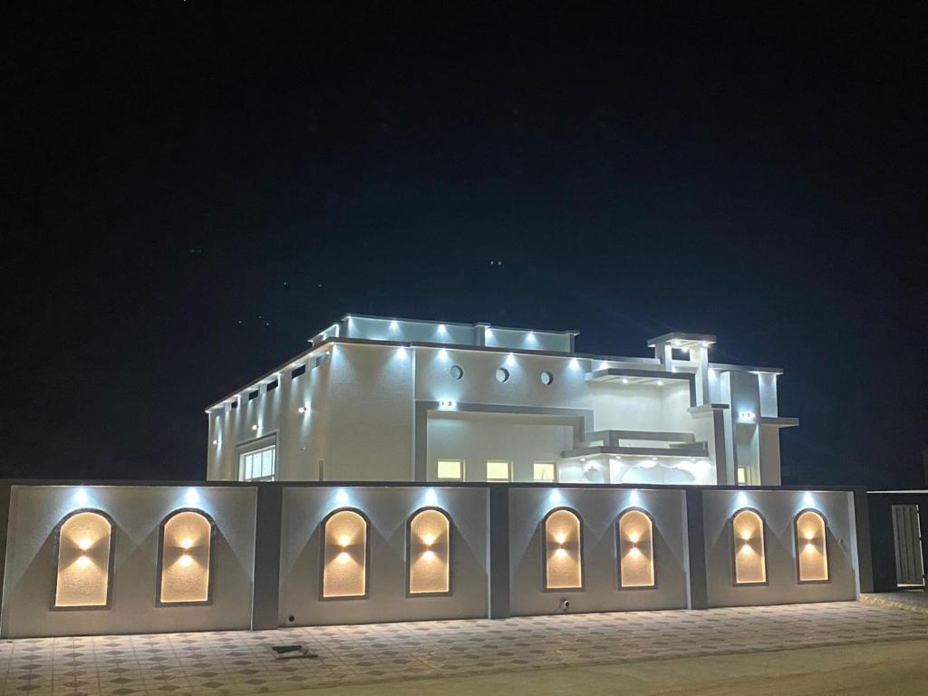 a building with lights on it at night at Al Saad chalet in Al Ashkharah
