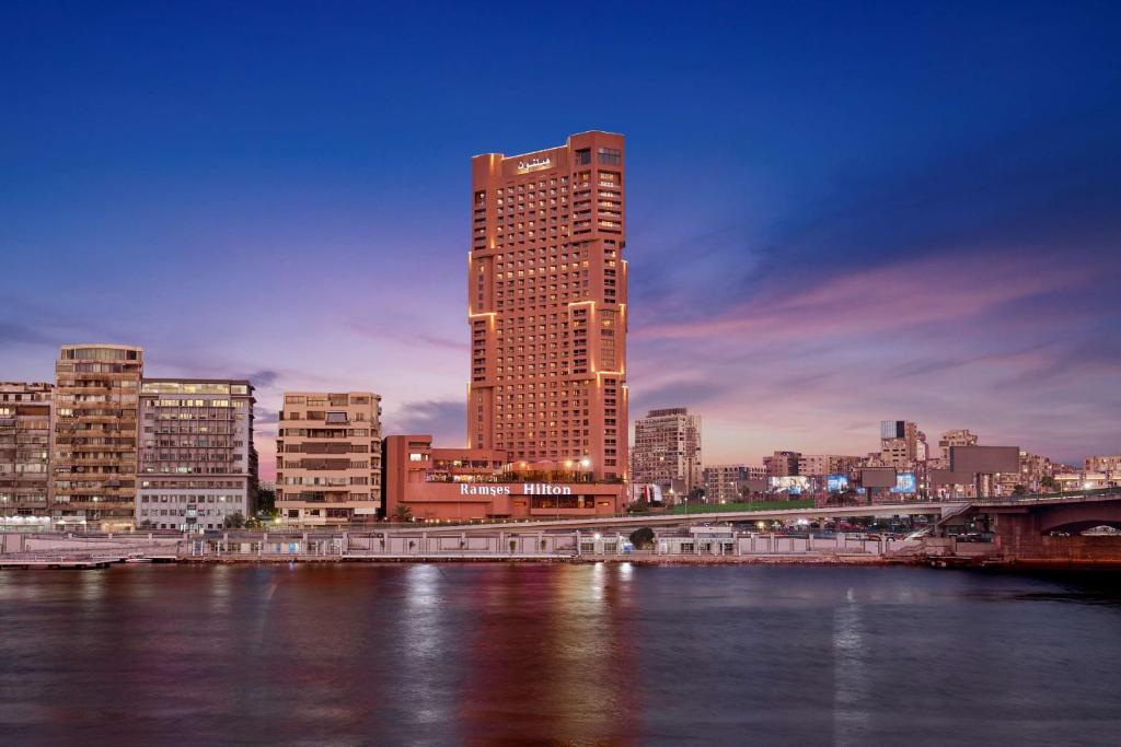 ein hohes Gebäude in einer Stadt neben einem Fluss in der Unterkunft Ramses Hilton Hotel & Casino in Kairo