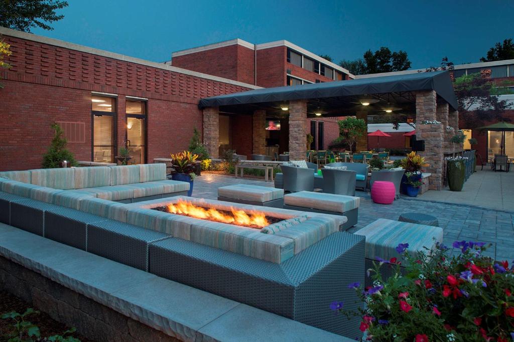 eine Terrasse mit einer Feuerstelle vor einem Gebäude in der Unterkunft Hilton Akron Fairlawn in Fairlawn