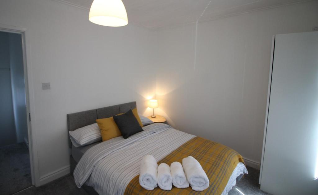 ベルファストにあるMountcollyer Avenue Manorのベッドルーム1室(ベッド1台、白いタオル2枚付)