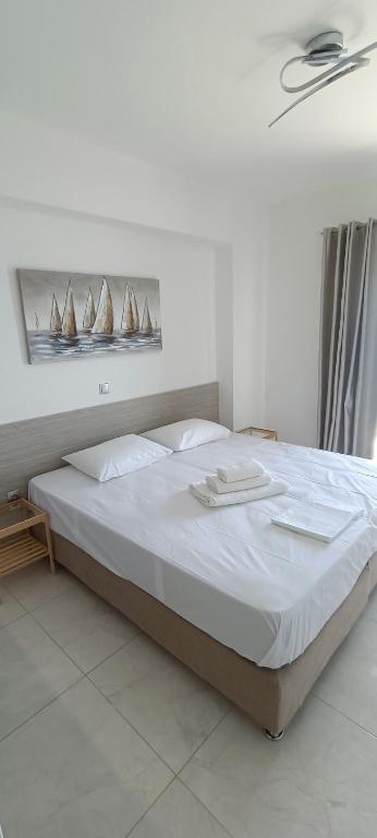 Ein Schlafzimmer mit einem großen weißen Bett und Bootsmotiven an der Wand in der Unterkunft Christinas 1 in Nerántza