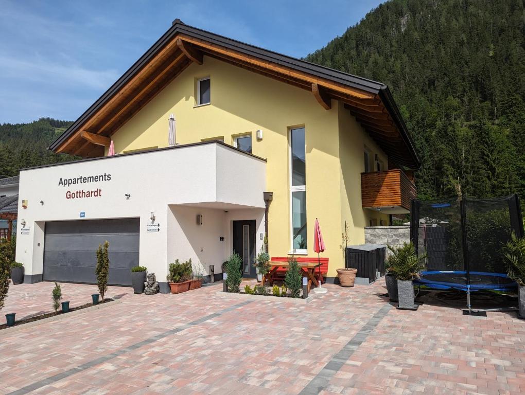 a large yellow and white building with a patio at Appartements Gotthardt in Flachau