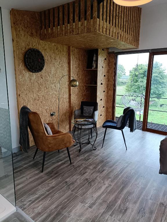 a living room with chairs and a table and a desk at Shed Loft apartment in Longford