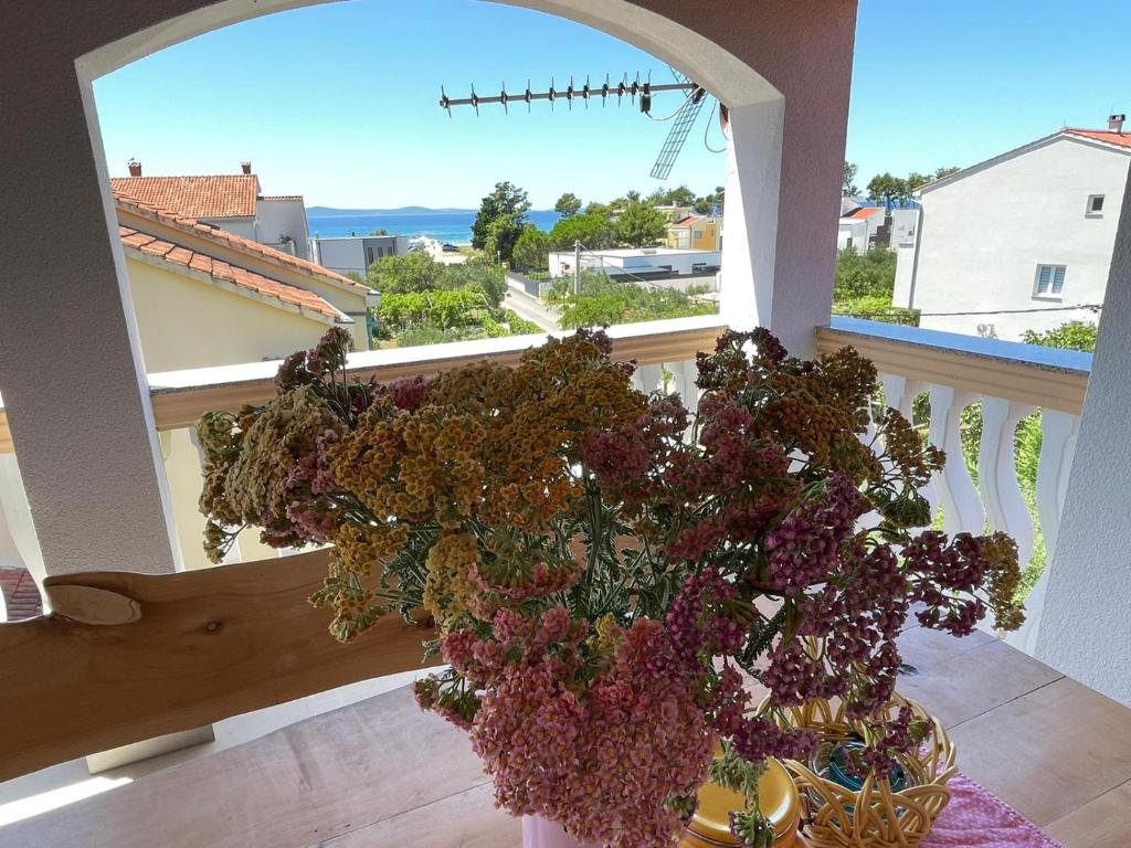 un vase de fleurs sur une table devant une fenêtre dans l'établissement Joyful apartments with beautiful view, à Privlaka