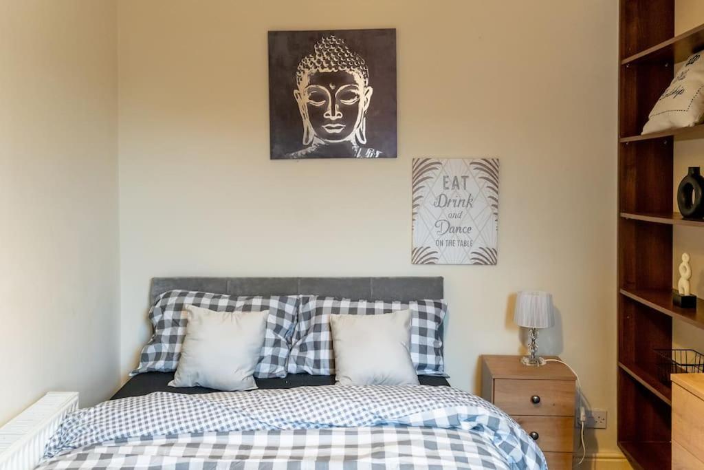 um quarto com uma cama e uma imagem de uma estátua em Amazing Entire 4 Bedroom Home em Manchester
