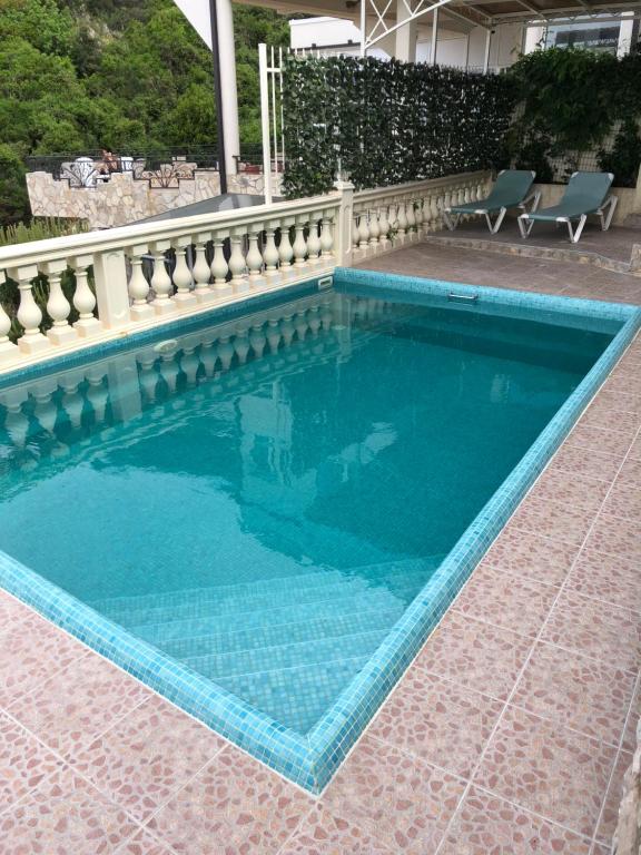 una piscina blu con recinzione e sedie di Семейный комплекс для отдыха a Pečurice