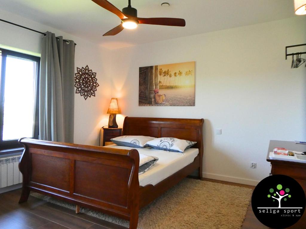 a bedroom with a bed and a ceiling fan at Seliga Sport Apartments & SPA in Lesznowola