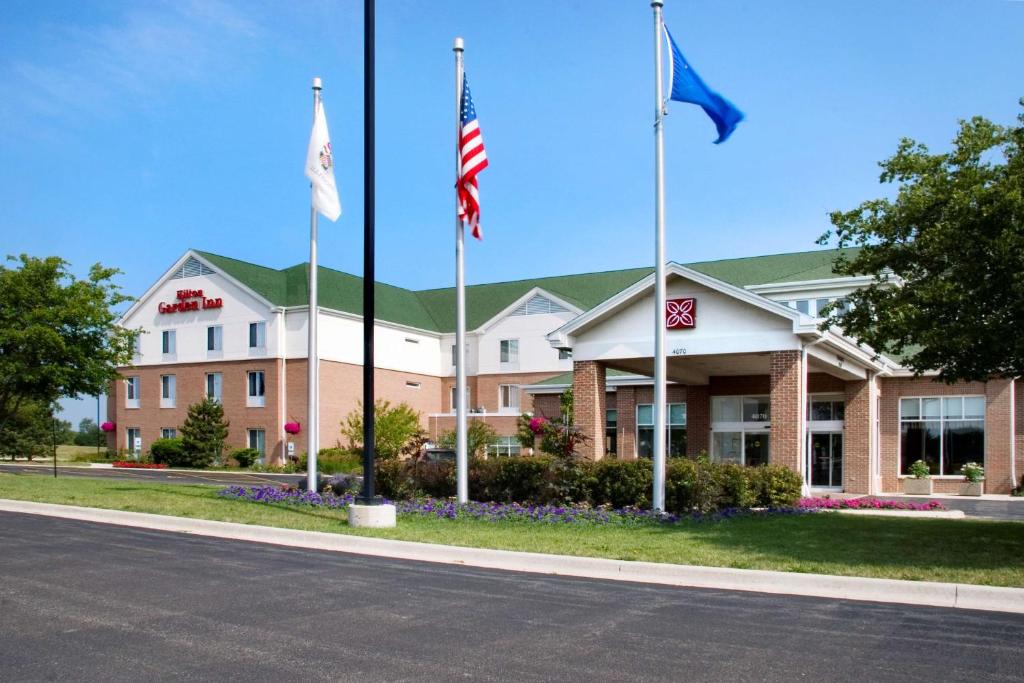 a hotel with three flags in front of it at Hilton Garden Inn Saint Charles in Saint Charles