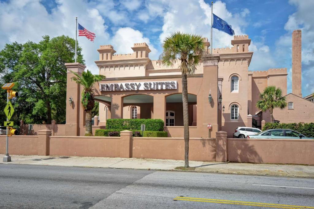 a building with two flags on top of it at Embassy Suites Charleston - Historic District in Charleston