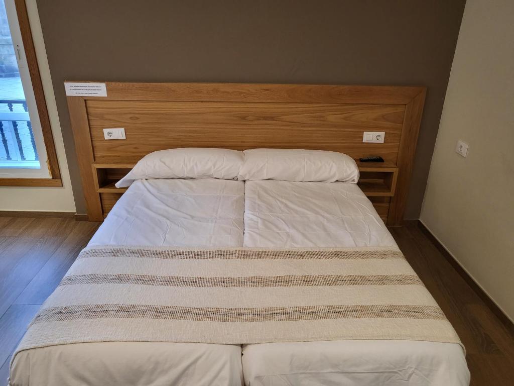 a bed with two pillows on it in a room at CASA MARUXA pensión in Pontevedra