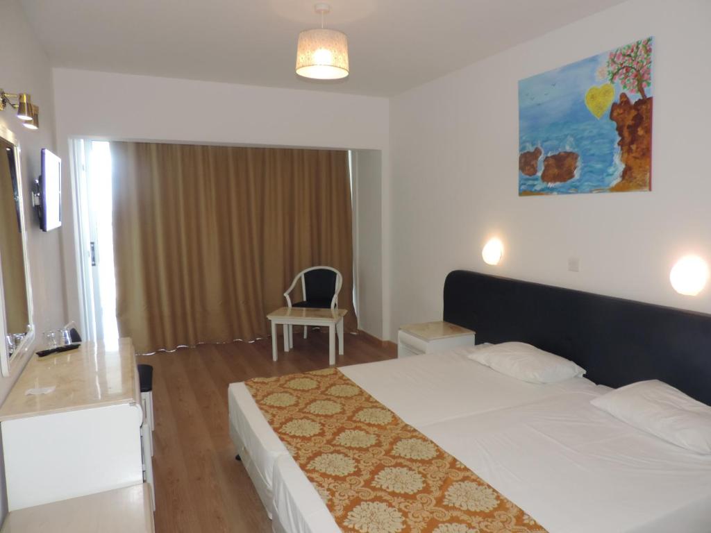 a bedroom with a bed and a chair in it at Corfu Hotel in Ayia Napa