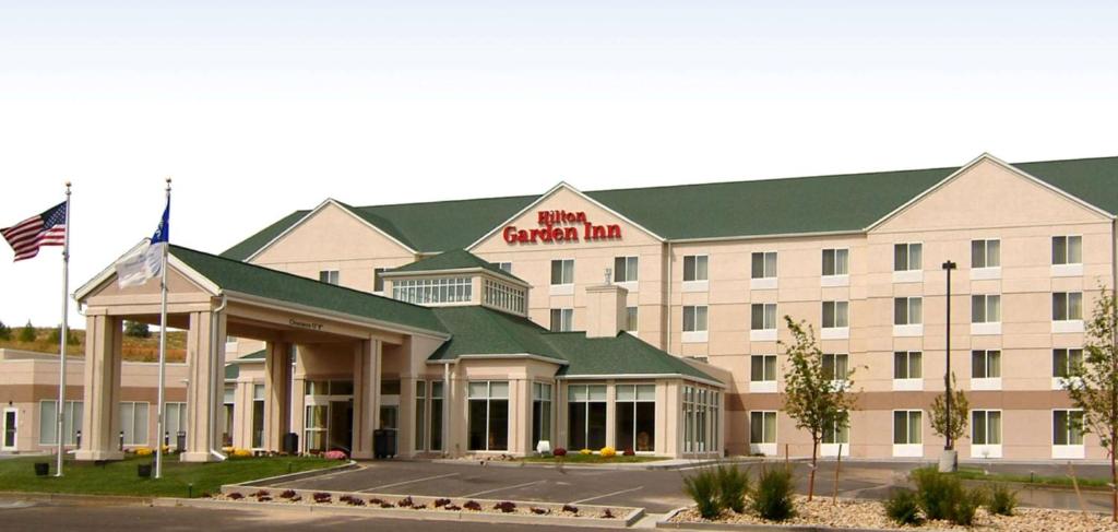 a hotel building with an american inn sign on it at Hilton Garden Inn Casper in Casper