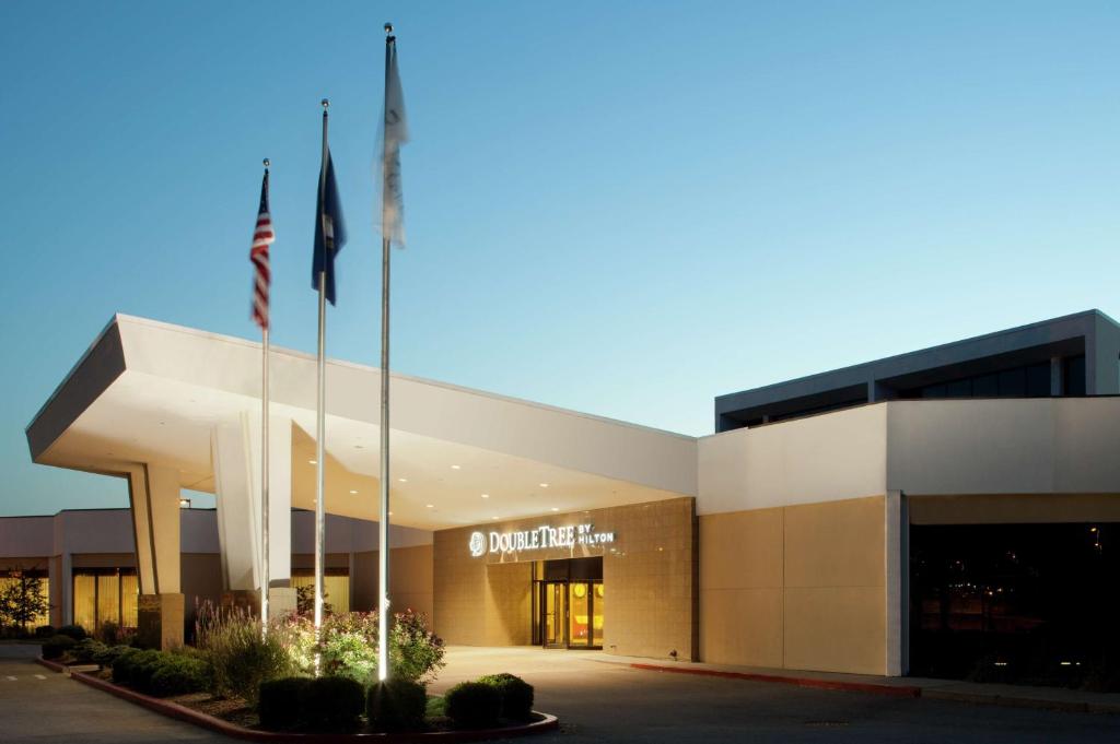 un edificio con dos banderas delante en DoubleTree by Hilton Cincinnati Airport, en Hebron