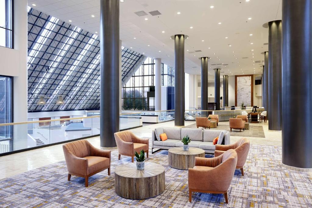 un vestíbulo con sofás, mesas y ventanas en DoubleTree by Hilton Dallas Near the Galleria, en Dallas