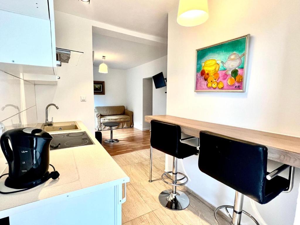 a kitchen with a counter and a kitchen island with chairs at Familly Apartament 4 in Międzyzdroje