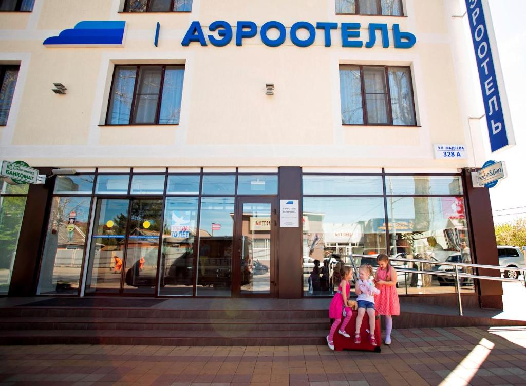 eine Gruppe von Kindern, die außerhalb eines Ladens stehen in der Unterkunft Krasnodar Aerohotel in Krasnodar