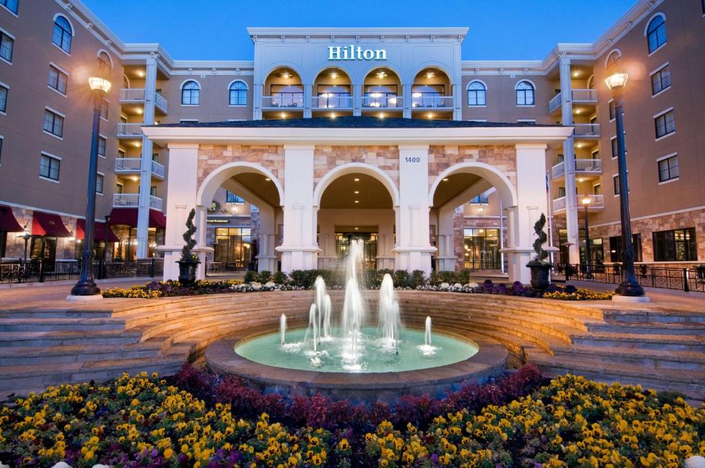 a fountain in the middle of a plaza in front of a hotel at Hilton Dallas Southlake Town Square in Southlake