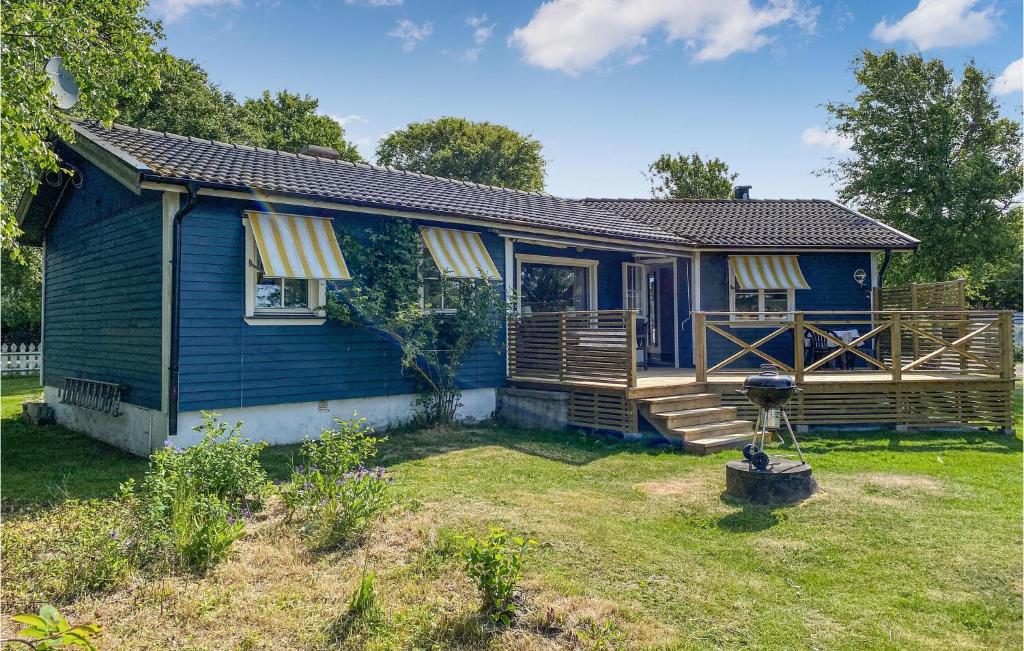 una casa azul con porche y patio en Stunning Home In Glommen With House Sea View, en Glommen
