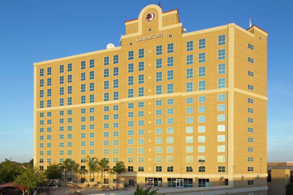 a yellow building with a clock on top of it at DoubleTree by Hilton Modesto in Modesto