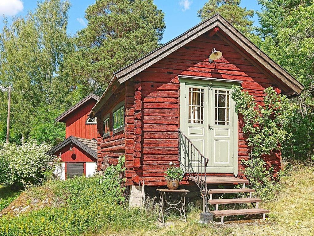 une petite cabine rouge avec une porte blanche et des escaliers dans l'établissement Holiday home SÖDERBÄRKE, à Söderbärke